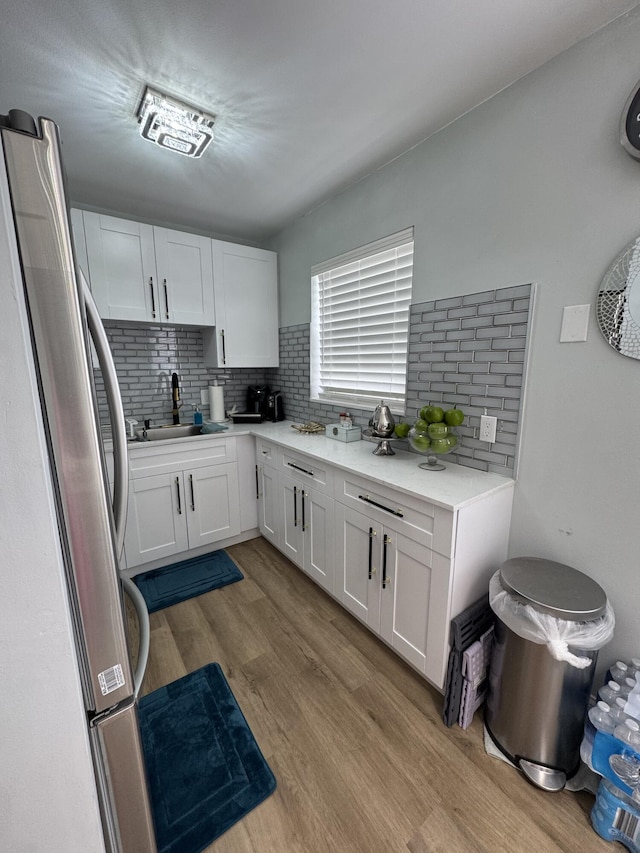 203 S Windsor I Unit 203, West Palm Beach, FL 33417 - kitchen featuring freestanding refrigerator, white cabinets, light wood-style floors, light countertops, and a sink