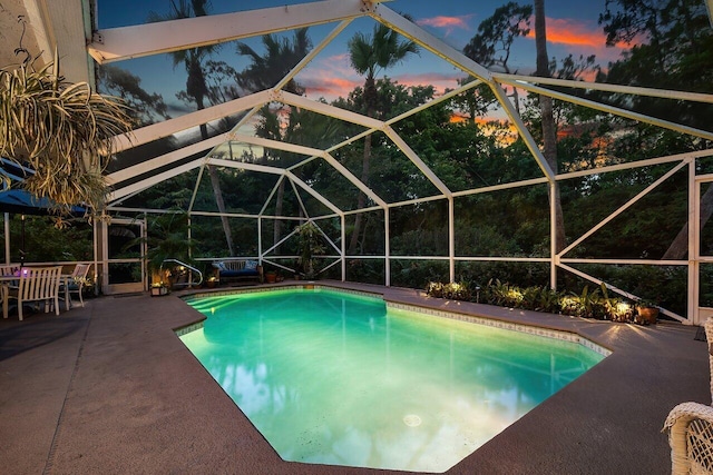 16243 E Calder Dr, Loxahatchee, FL 33470 - pool at dusk with an outdoor pool, a patio, and glass enclosure