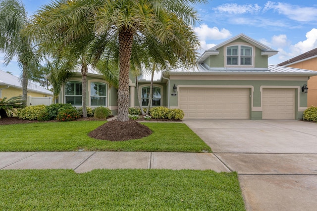 169 Stony Point Dr, Sebastian, FL 32958 - view of front facade with stucco siding, driveway, a front yard, and metal roof