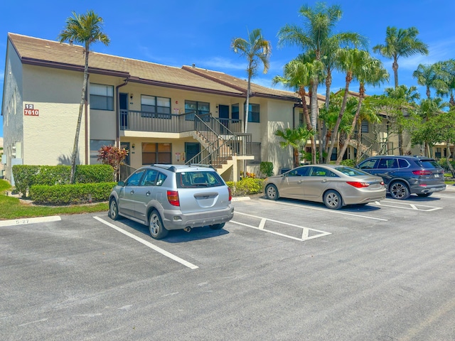 7610 Tahiti Ln Unit 201, Lake Worth, FL 33467 - view of building exterior featuring stairway and uncovered parking