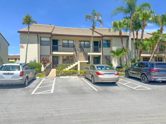 7610 Tahiti Ln Unit 201, Lake Worth, FL 33467 - view of building exterior featuring stairway and uncovered parking