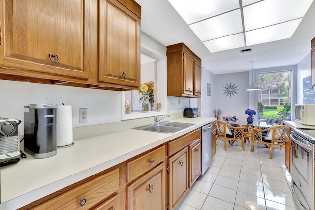 19819 Boca W Dr Unit 4033, Boca Raton, FL 33434 - kitchen with stainless steel appliances, light tile patterned flooring, a sink, brown cabinets, and light countertops