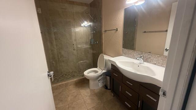 425 Lake Helen Dr, West Palm Beach, FL 33411 - full bath with vanity, a stall shower, toilet, and tile patterned flooring