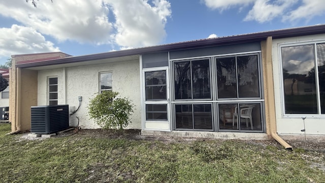 425 Lake Helen Dr, West Palm Beach, FL 33411 - view of home's exterior with central AC, a yard, and stucco siding