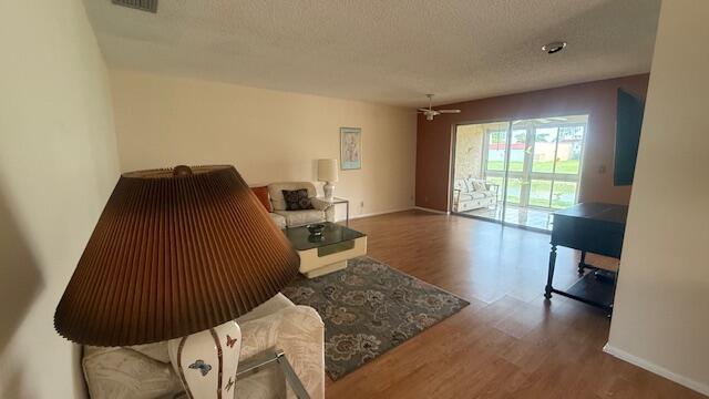 425 Lake Helen Dr, West Palm Beach, FL 33411 - living area with wood finished floors, a textured ceiling, ceiling fan, and baseboards