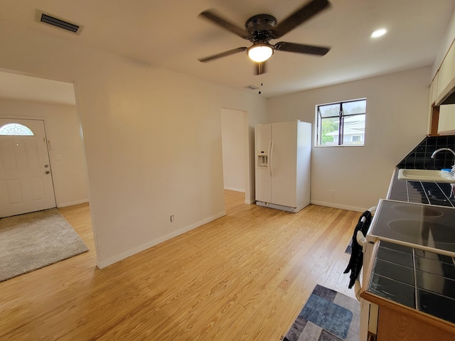 510 N 5th St, Lantana, FL 33462 - kitchen featuring white refrigerator with ice dispenser, tile counters, a sink, ceiling fan, and light wood-type flooring