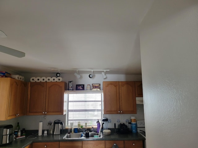 510 N 5th St, Lantana, FL 33462 - kitchen featuring dark countertops, decorative backsplash, track lighting, and brown cabinetry