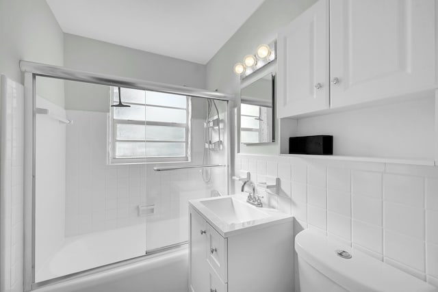 2135 NE 4th Way, Boca Raton, FL 33431 - full bathroom with vanity, bath / shower combo with glass door, tile walls, and toilet