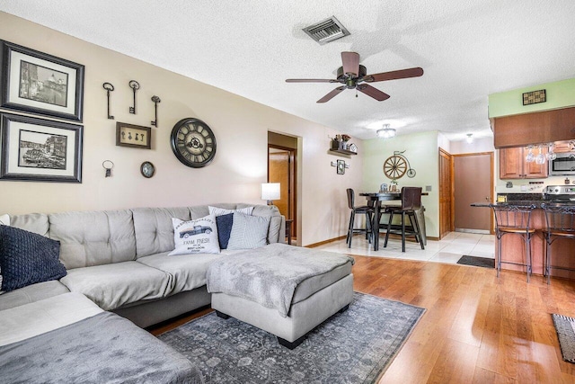 129 Parkwood Dr, Royal Palm Beach, FL 33411 - living room featuring ceiling fan, a textured ceiling, and light wood-style floors