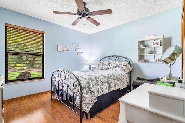 129 Parkwood Dr, Royal Palm Beach, FL 33411 - bedroom featuring wood finished floors, a textured ceiling, baseboards, and ceiling fan