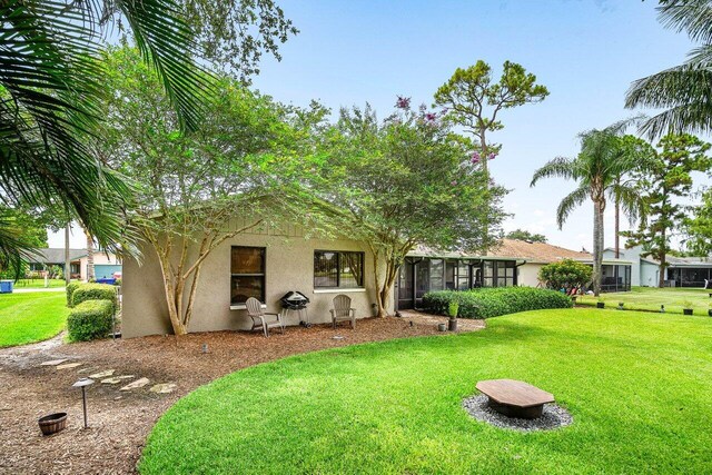 129 Parkwood Dr, Royal Palm Beach, FL 33411 - rear view of property featuring stucco siding and a lawn