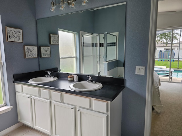 426 Cadiz Loop, Davenport, FL 33837 - bathroom with a stall shower, double vanity, ensuite bath, a textured wall, and tile patterned flooring