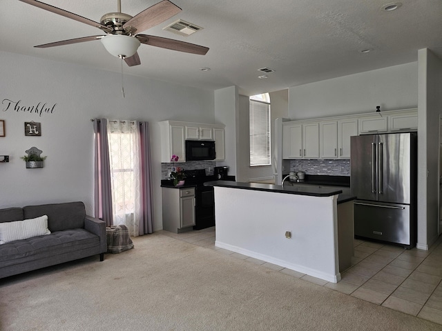 426 Cadiz Loop, Davenport, FL 33837 - kitchen featuring high end fridge, black microwave, dark countertops, light tile patterned floors, and backsplash