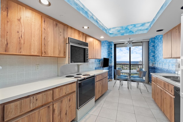 4740 S Ocean Blvd Unit 1403, Highland Beach, FL 33487 - kitchen featuring electric range, backsplash, light tile patterned flooring, light countertops, and floor to ceiling windows