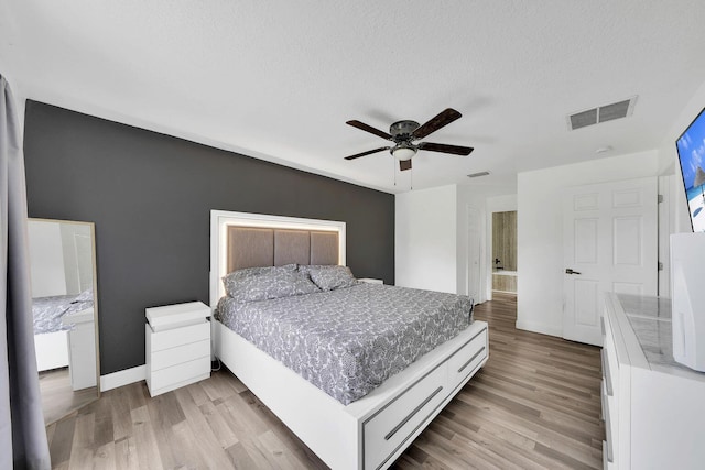 3990 Halcomb St, Port Saint Lucie, FL 34953 - bedroom featuring baseboards, light wood-style flooring, a ceiling fan, a textured ceiling, and ensuite bath