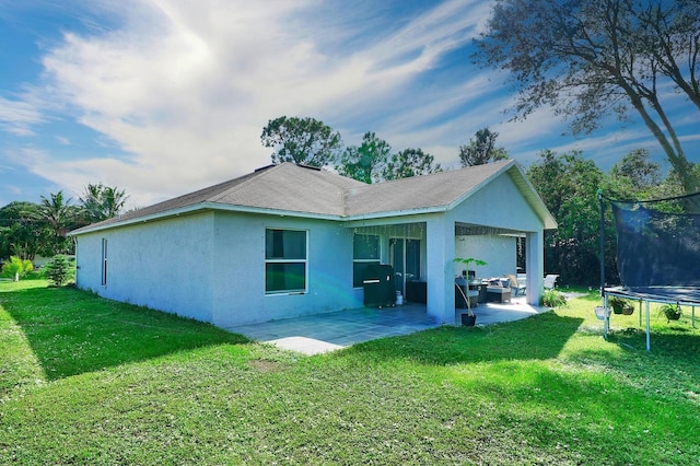 3990 Halcomb St, Port Saint Lucie, FL 34953 - back of property featuring a trampoline, a patio, stucco siding, and a lawn
