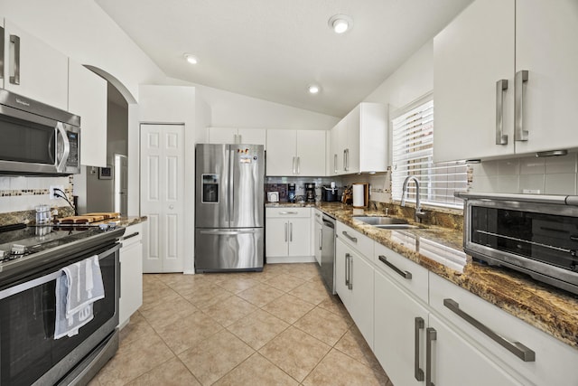 7116 Trentino Way, Boynton Beach, FL 33472 - kitchen featuring appliances with stainless steel finishes, lofted ceiling, decorative backsplash, a sink, and dark stone countertops