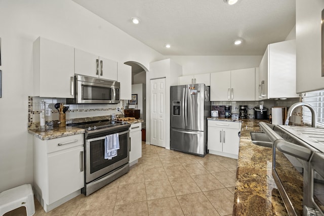 7116 Trentino Way, Boynton Beach, FL 33472 - kitchen with appliances with stainless steel finishes, tasteful backsplash, white cabinets, vaulted ceiling, and arched walkways