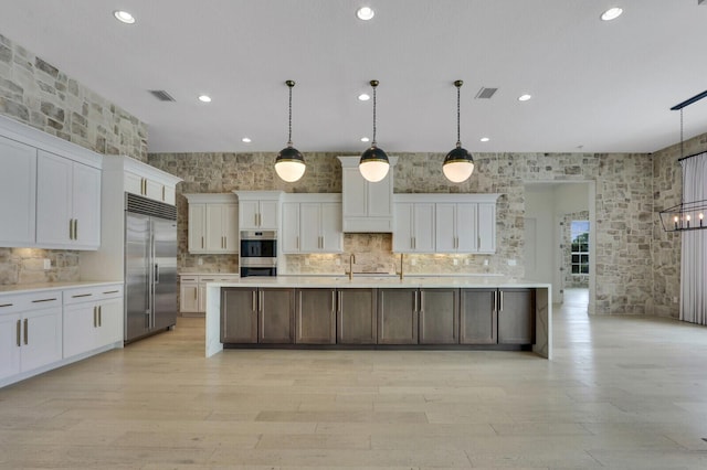 10032 Calabrese Trl, Jupiter, FL 33478 - kitchen with appliances with stainless steel finishes, a sink, light countertops, white cabinetry, and light wood-style flooring