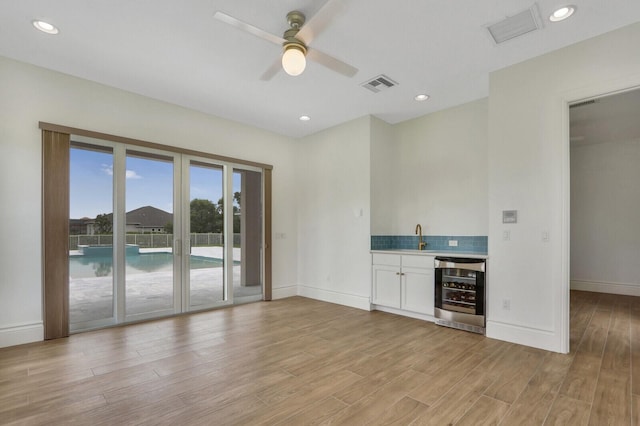 10032 Calabrese Trl, Jupiter, FL 33478 - indoor wet bar featuring beverage cooler, ceiling fan, light wood-style flooring, tasteful backsplash, and baseboards