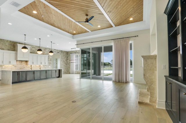 10032 Calabrese Trl, Jupiter, FL 33478 - unfurnished living room featuring wooden ceiling, ceiling fan, light wood-type flooring, baseboards, and a raised ceiling