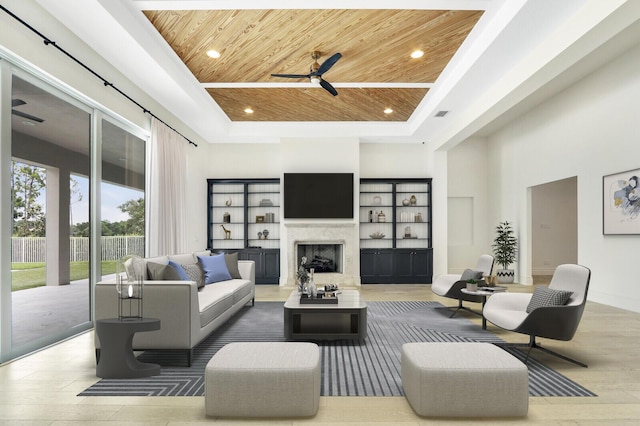 10032 Calabrese Trl, Jupiter, FL 33478 - living area featuring wooden ceiling, a tray ceiling, ceiling fan, a fireplace, and recessed lighting