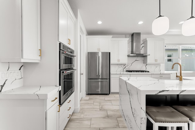 11244 SW Lyra Dr, Port Saint Lucie, FL 34987 - kitchen featuring appliances with stainless steel finishes, wall chimney exhaust hood, decorative backsplash, white cabinetry, and a sink