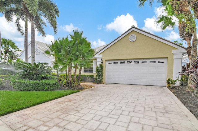 9278 Heathridge Dr, West Palm Beach, FL 33411 - view of front of house featuring stucco siding, decorative driveway, and an attached garage