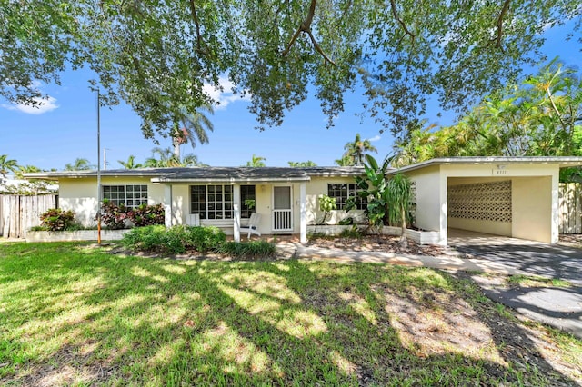 4311 NE 16th Ave, Oakland Park, FL 33334 - ranch-style home with stucco siding, a carport, and driveway