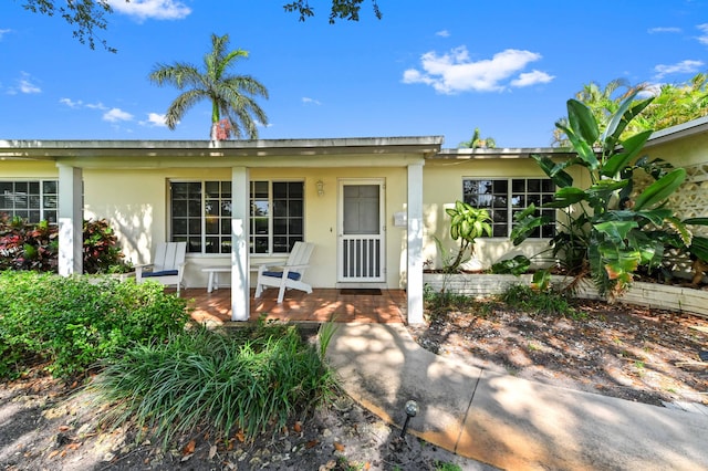 4311 NE 16th Ave, Oakland Park, FL 33334 - ranch-style home with stucco siding and a porch