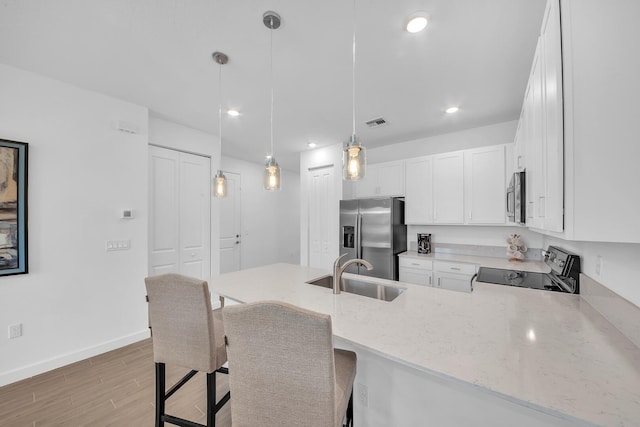 14517 Three Ponds Trl, Delray Beach, FL 33446 - kitchen with appliances with stainless steel finishes, a sink, light wood-type flooring, a peninsula, and white cabinetry