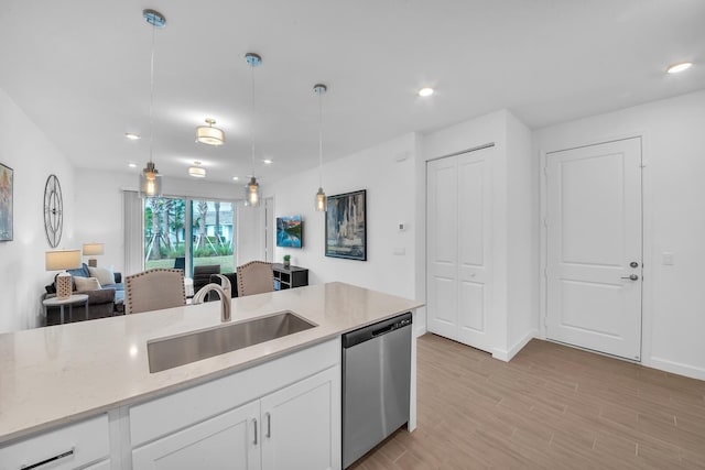 14517 Three Ponds Trl, Delray Beach, FL 33446 - kitchen featuring dishwasher, a sink, white cabinetry, light stone counters, and hanging light fixtures