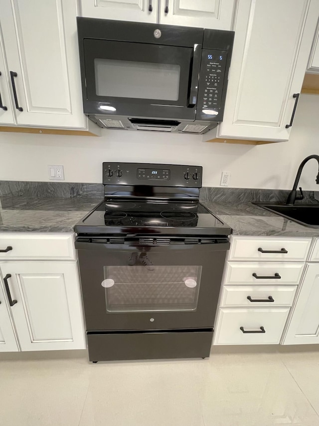 1225 NW 21st St NW Unit 15-1505, Stuart, FL 34994 - kitchen with black appliances, white cabinetry, a sink, and tile patterned flooring