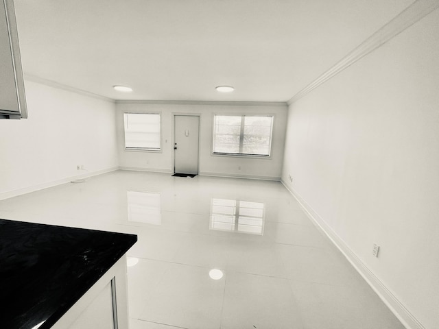 1225 NW 21st St NW Unit 15-1505, Stuart, FL 34994 - unfurnished living room featuring crown molding, light tile patterned flooring, and baseboards