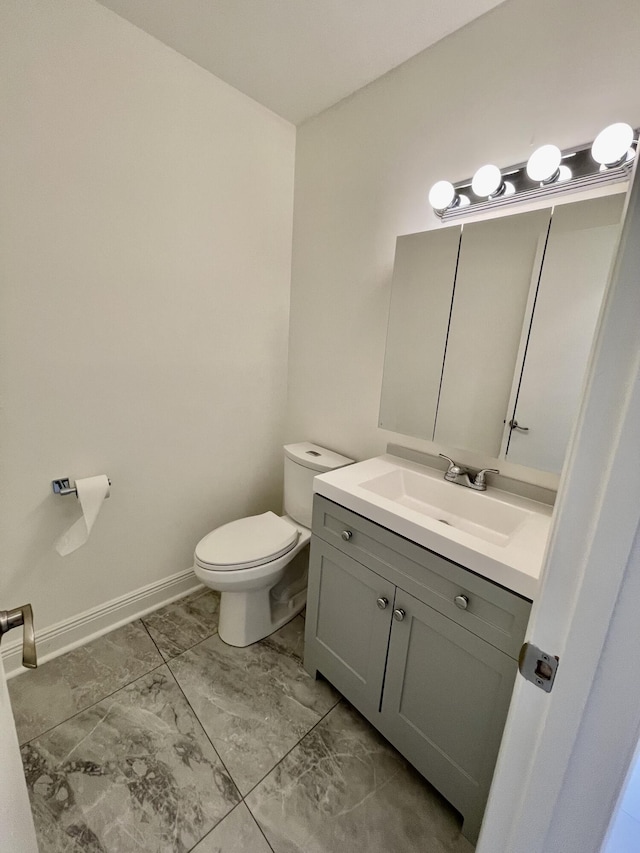 1225 NW 21st St NW Unit 15-1505, Stuart, FL 34994 - half bathroom featuring toilet, marble look tiles, vanity, and baseboards