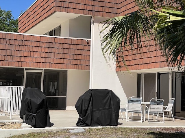 1225 NW 21st St NW Unit 15-1505, Stuart, FL 34994 - rear view of house featuring stucco siding, a patio, and mansard roof