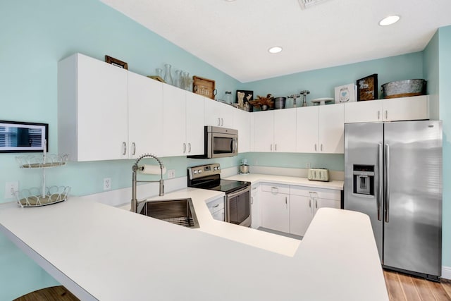 7989 Lakewood Cove Ct, Lake Worth, FL 33467 - kitchen featuring stainless steel appliances, light countertops, light wood-style flooring, a peninsula, and recessed lighting
