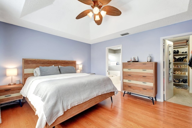 7989 Lakewood Cove Ct, Lake Worth, FL 33467 - bedroom featuring light wood-type flooring, a ceiling fan, a spacious closet, and ensuite bath