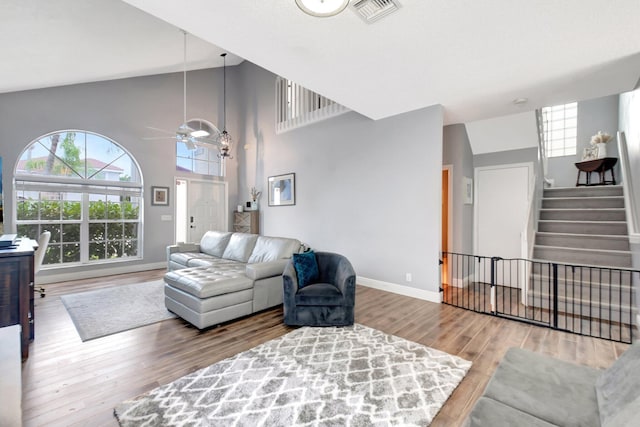 7989 Lakewood Cove Ct, Lake Worth, FL 33467 - living room with wood finished floors, high vaulted ceiling, stairs, a ceiling fan, and baseboards