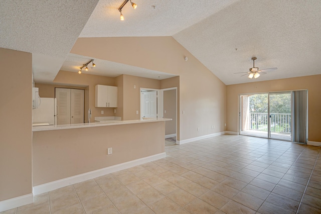3870 Lyons Rd Unit 308-8, Coconut Creek, FL 33073 - unfurnished living room with rail lighting, a textured ceiling, a ceiling fan, baseboards, and a sink