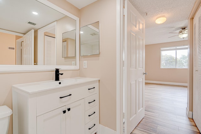 3870 Lyons Rd Unit 308-8, Coconut Creek, FL 33073 - bathroom with vanity, toilet, ceiling fan, baseboards, and wood finished floors