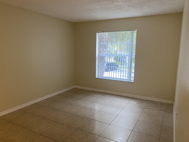 405 W Executive Center Dr Unit 208, West Palm Beach, FL 33401 - unfurnished room featuring healthy amount of natural light, light tile patterned flooring, a textured ceiling, and baseboards