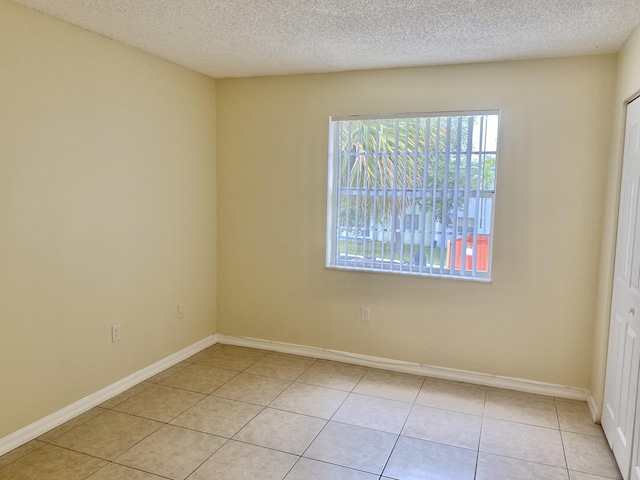 405 W Executive Center Dr Unit 208, West Palm Beach, FL 33401 - spare room featuring light tile patterned floors, baseboards, and a textured ceiling