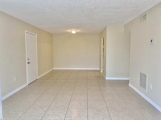 405 W Executive Center Dr Unit 208, West Palm Beach, FL 33401 - empty room featuring a textured ceiling, light tile patterned floors, and baseboards