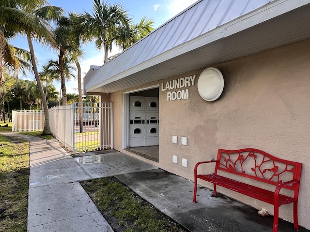 405 W Executive Center Dr Unit 208, West Palm Beach, FL 33401 - entrance to property with separate washer and dryer, metal roof, stucco siding, and a standing seam roof