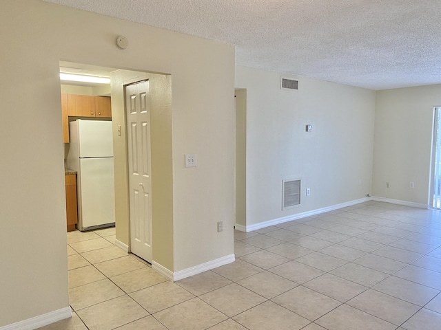 405 W Executive Center Dr Unit 208, West Palm Beach, FL 33401 - unfurnished room with light tile patterned flooring, a textured ceiling, a smoke detector, and baseboards