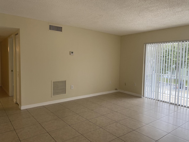 405 W Executive Center Dr Unit 208, West Palm Beach, FL 33401 - spare room featuring light tile patterned floors, a textured ceiling, and baseboards