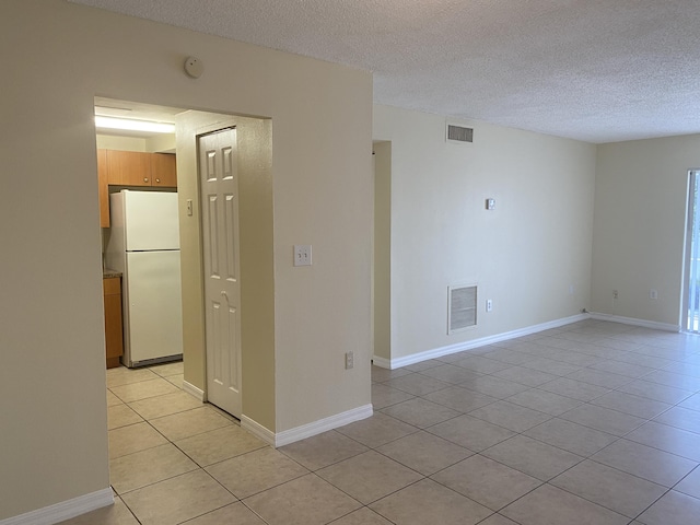 405 W Executive Center Dr Unit 208, West Palm Beach, FL 33401 - unfurnished room featuring light tile patterned flooring, a textured ceiling, a smoke detector, and baseboards