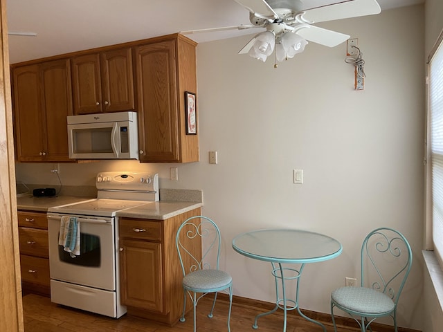 6004 Indrio Rd Unit 2, Fort Pierce, FL 34951 - kitchen featuring stainless steel microwave, white electric range, light countertops, light wood-style floors, and brown cabinetry