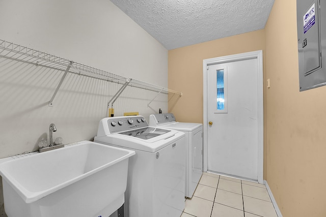 654 SW Kayak Ave, Port Saint Lucie, FL 34953 - laundry room with washer and clothes dryer, electric panel, light tile patterned floors, baseboards, and a textured ceiling